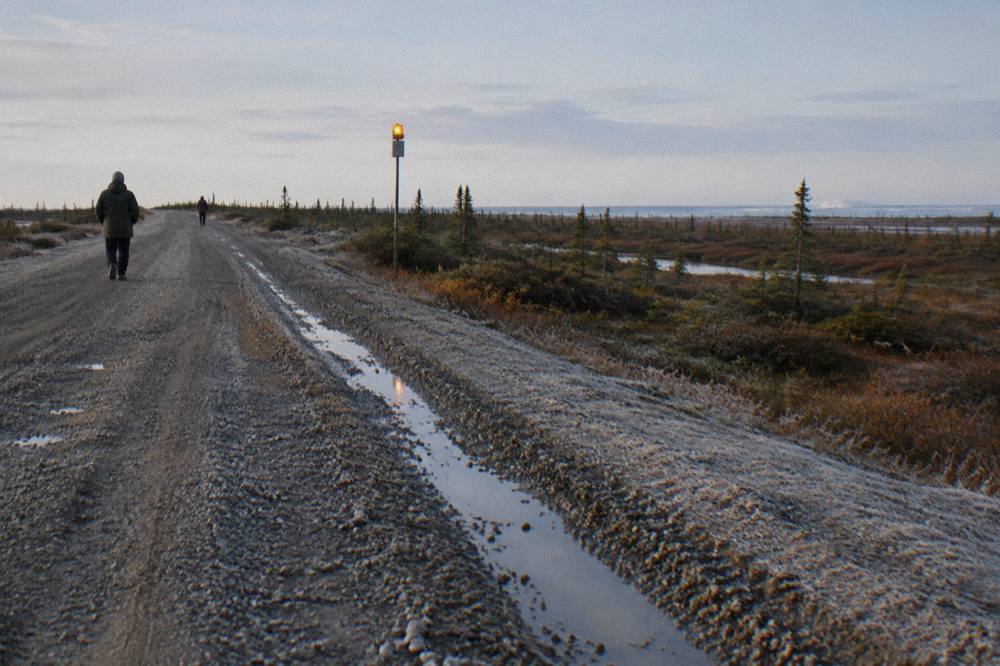A wide gravel road on the edge of Churchill under a pale subarctic sky