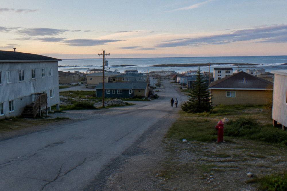 A small northern town street with modest buildings under a wide open sky