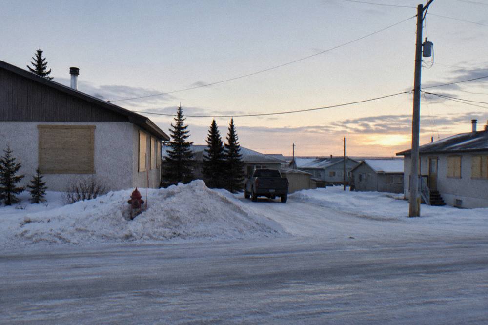 A small northern town street with low buildings under a wide evening sky