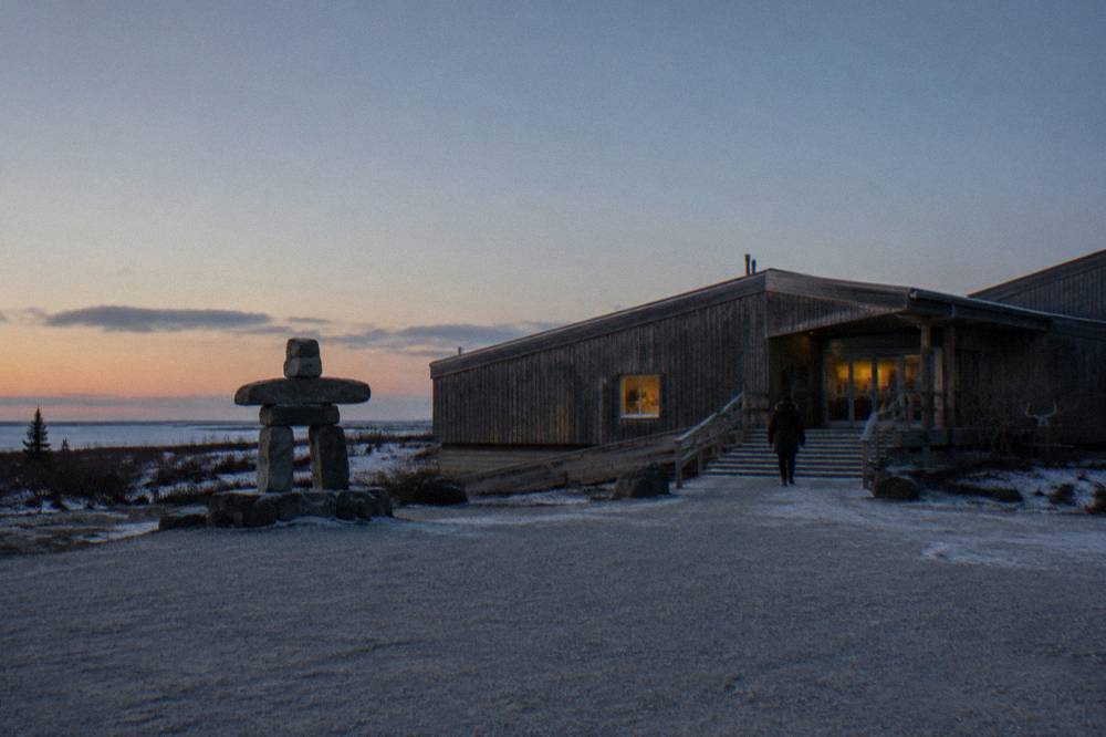 A small northern town street with low buildings and a wide open sky at dusk
