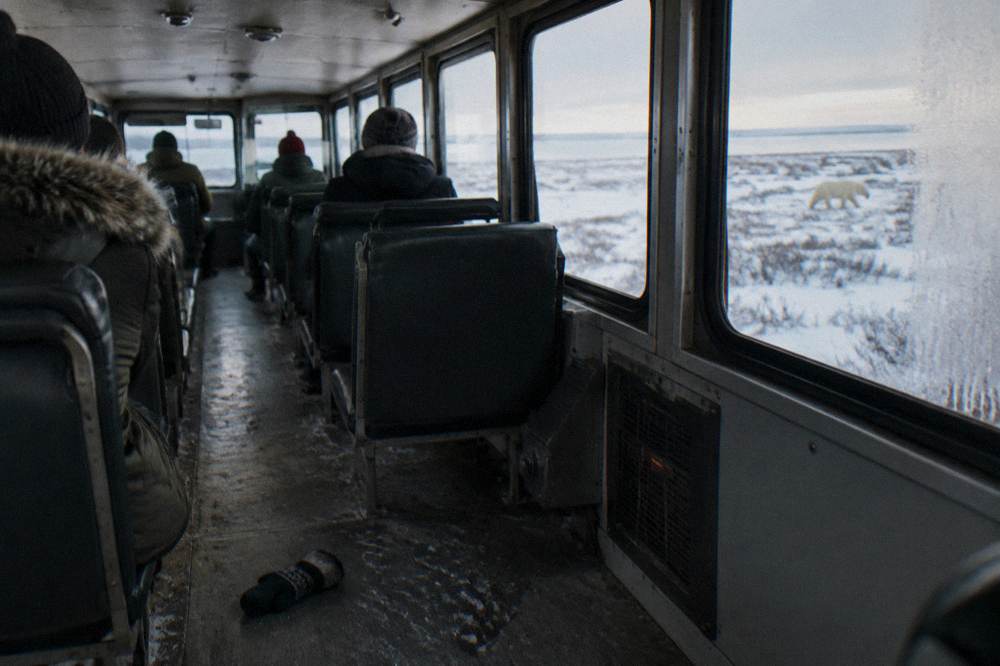 The interior cabin of a raised tundra vehicle with rows of window seats and a heating unit