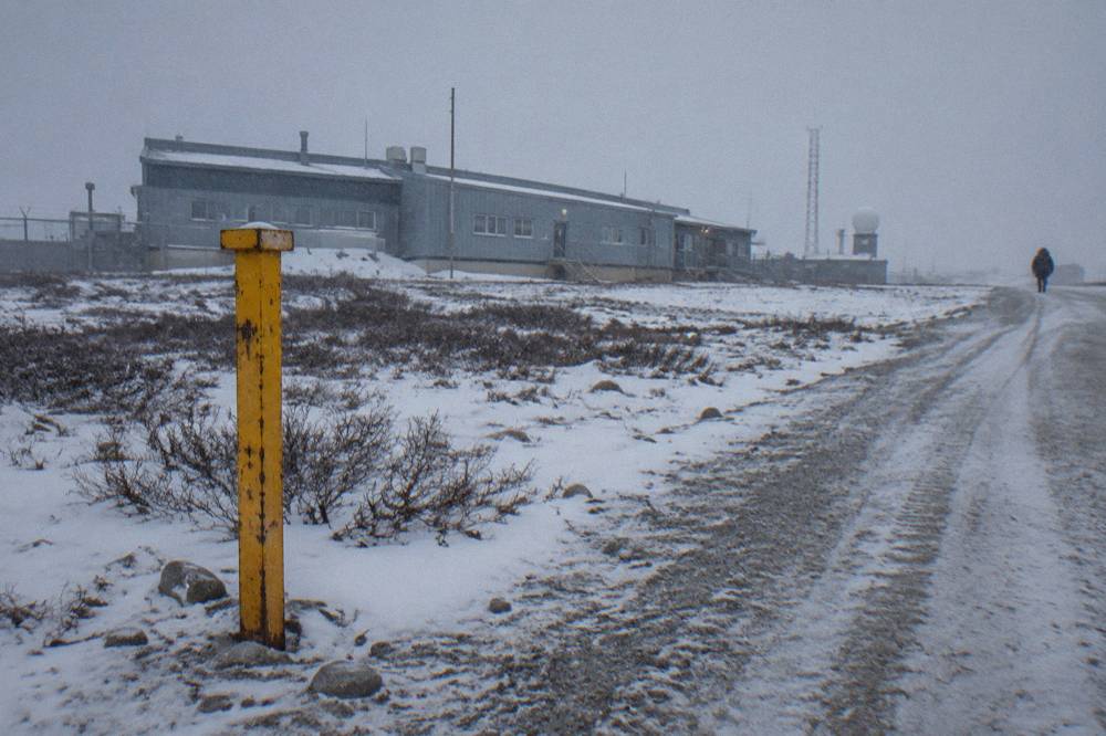 A sign warning of polar bears in the area standing beside a coastal road in a small northern town