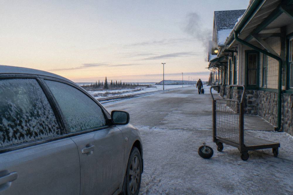 A passenger train waiting at a northern station platform in cold morning light
